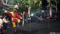 Salah seorang penari mengelilingi bambu berbalut kain merah Syanti detikTravel
