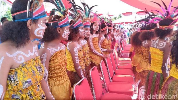 Remaja putri Papua menyambut kedatangan Jokowi.