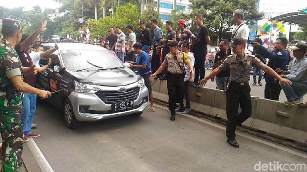  Personel gabungan Polri dan TNI menghalau massa driver online yang mengepung satu mobil di depan Kemenhub, Senin (29/1/2018)