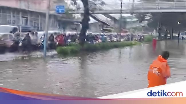 tim bpbd jakarta membersihkan genangan air di jalan raya