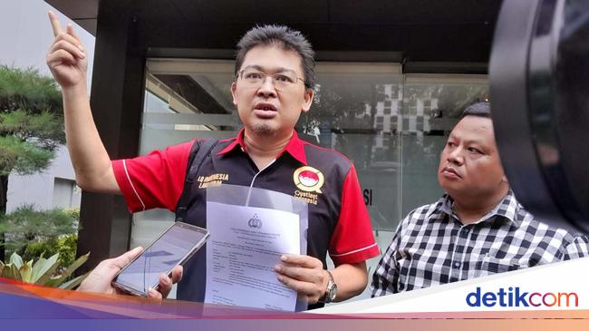 Alvin Lim berdiri di atas panggung dengan piala penghargaan di tangan