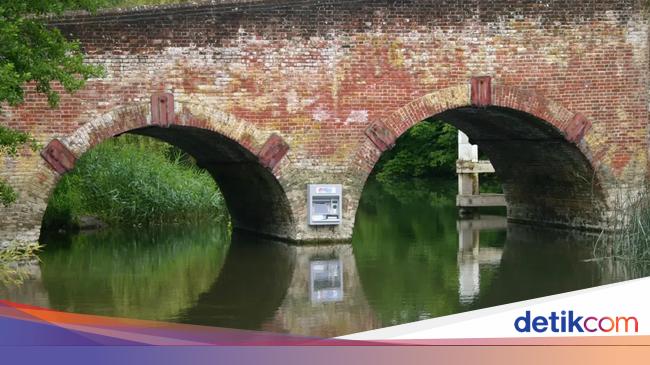 Agak Laen! Mesin ATM Ini Nempel di Tiang Jembatan Tengah Sungai
