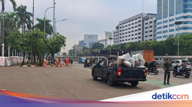Petugas PPSU Bersihkan Sisa Sampah Pascademo di Depan Gedung DPR