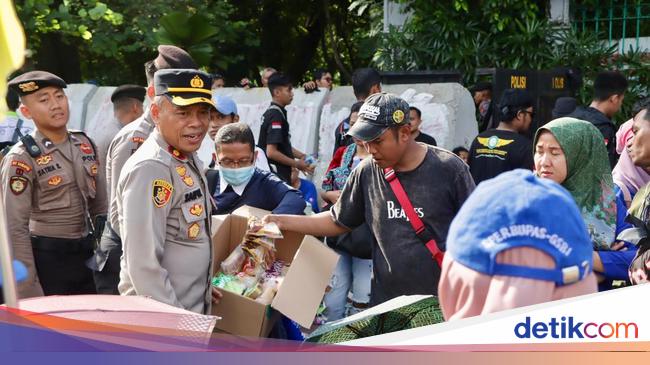 Aksi Polisi Bagikan Air Mineral dan Roti ke Massa Demo Buruh di Monas