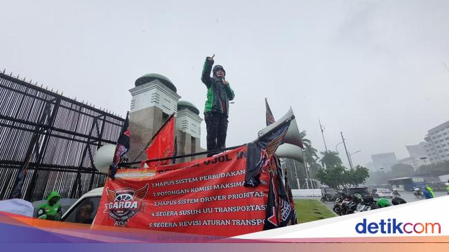 Diguyur Hujan, Massa Ojol Suarakan Potongan Aplikator 10% di Depan DPR