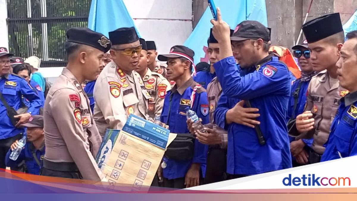 Aksi Polisi Bagikan Air Mineral dan Roti ke Massa Buruh di DPR