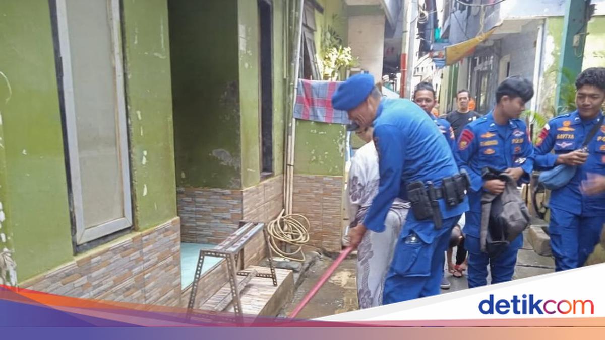 Polairud Polda Metro Bantu Bersihkan Lumpur Sisa Banjir di Kampung Melayu