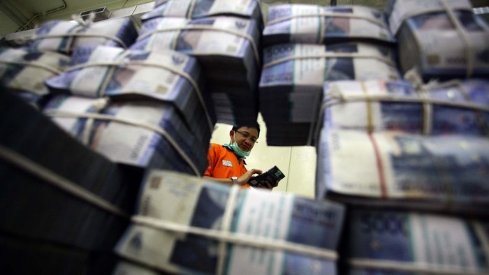 BUMN percetakan uang, Perum Peruri dibanjiri pesanan cetak uang dari Bank Indonesia (BI). Pihak Peruri mengaku sangat kewalahan untuk memenuhi pesanan uang dari BI yang mencapai miliaran lembar. Seorang petugas tampak merapihkan tumpukan uang di cash center Bank Negara Indonesia Pusat, kawasan Sudirman, Jakarta, Senin (21/10/2013). (FOTO: Rachman Haryanto/detikFoto)