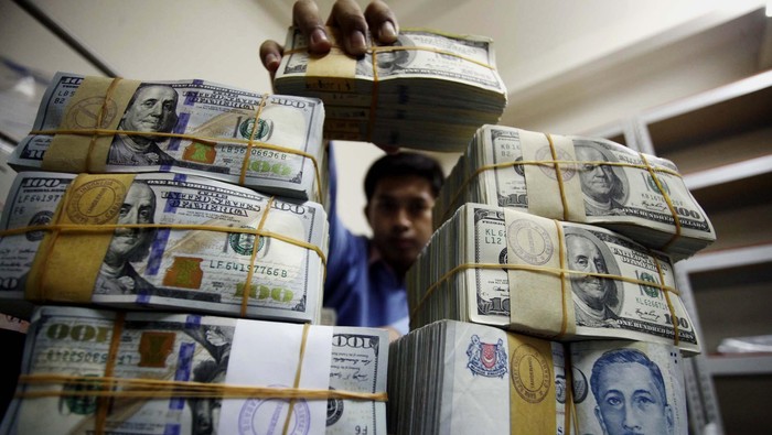 Pekerja merapihkan uang Dollar dan Rupiah di Cash Center BRI Pusat, Jakarta, Kamis (5/6/2014). Nilai tukar rupiah hingga penutupan perdagangan sore pekan ini hampir menyentuh angka Rp 12.000 per-dollar US.