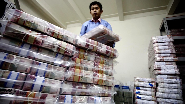 Pekerja merapihkan uang Dollar dan Rupiah di Cash Center BRI Pusat, Jakarta, Kamis (5/6/2014). Nilai tukar rupiah hingga penutupan perdagangan sore pekan ini hampir menyentuh angka Rp 12.000 per-dollar US.
