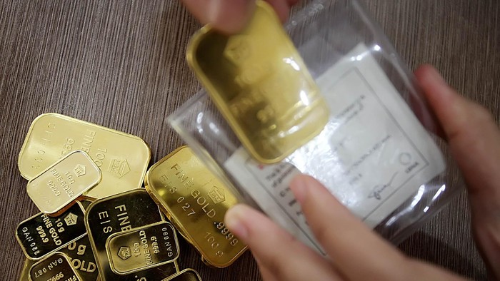 Seorang customer service Bank BNI Syariah cabang Benhil Jakarta Pusat menunjukkan logam mulia emas batangan berukuran 10 dan 100 gram, akhir pekan lalu. Berdasarkan data Asosiasi Pengusaha Emas dan Permata Indonesia, penjualan emas terus meningkat meskipun nilai tukar rupiah anjlok terhadap dollar AS. Jakarta (8/26/2013)