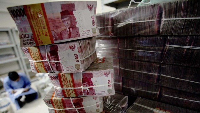 Pekerja merapihkan uang Dollar dan Rupiah di Cash Center BRI Pusat, Jakarta, Kamis (5/6/2014). Nilai tukar rupiah hingga penutupan perdagangan sore pekan ini hampir menyentuh angka Rp 12.000 per-dollar US.