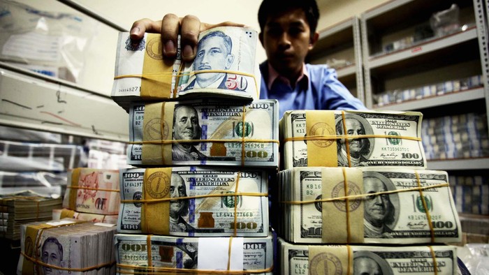 Pekerja merapihkan uang Dollar dan Rupiah di Cash Center BRI Pusat, Jakarta, Kamis (5/6/2014). Nilai tukar rupiah hingga penutupan perdagangan sore pekan ini hampir menyentuh angka Rp 12.000 per-dollar US.