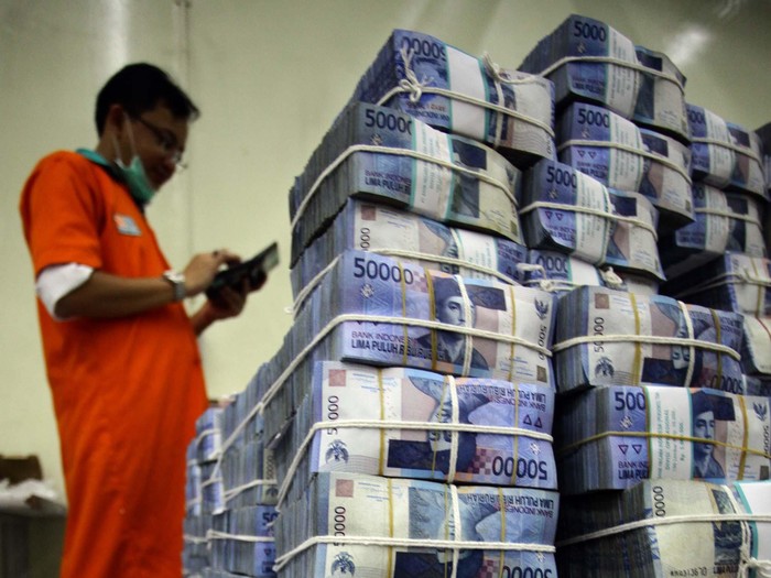 BUMN percetakan uang, Perum Peruri dibanjiri pesanan cetak uang dari Bank Indonesia (BI). Pihak Peruri mengaku sangat kewalahan untuk memenuhi pesanan uang dari BI yang mencapai miliaran lembar. Seorang petugas tampak merapihkan tumpukan uang di cash center Bank Negara Indonesia Pusat, kawasan Sudirman, Jakarta, Senin (21/10/2013). (FOTO: Rachman Haryanto/detikFoto)