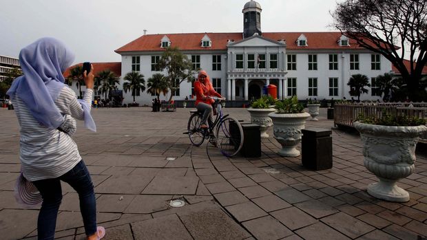 Wisatawan berwisata di halaman Museum Fatahillah Kawasan Kota Tua, Jakarta, Senin (4/2/2013). Pemerintah Provinsi DKI Jakarta melakukan penataan PKL disekitar Museum Fatahillah serta mempercantik kawasan Kota Tua tersebut guna menjaga keindahan dan ketertiban demi kenyamanan pengunjung.