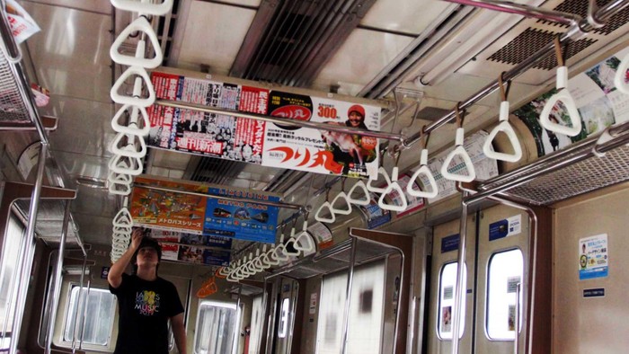 Seorang warga melihat Kereta Rel Listrik (KRL) bekas dari Jepang yang selesai diturunkan dari kapal di kawasan pelabuhan Tanjung Priok, Jakarta, Selasa (15/5/2012). Sebanyak 16 unit KRL seri 8500 yang masih terlihat aslinya, berhuruf kanji Jepang,  akan menambah kapasitas angkut KRL Jabotabek.