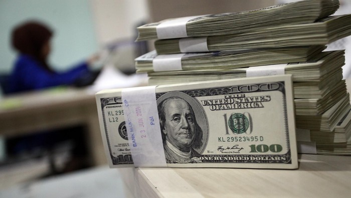 Seorang petugas menata uang dollar di Jakarta, Senin (30/6/2014). Nilai tukar dolar Amerika Serikat (AS) terus menguat terhadap rupiah sehingga mendorong minat masyarakat untuk berburu mata uang negeri Paman Sam ini.