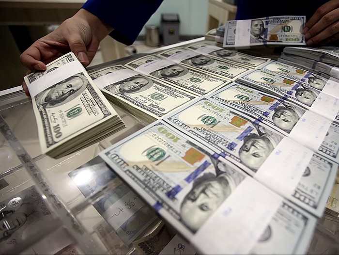 Seorang petugas menata uang dollar di Jakarta, Senin (30/6/2014). Nilai tukar dolar Amerika Serikat (AS) terus menguat terhadap rupiah sehingga mendorong minat masyarakat untuk berburu mata uang negeri Paman Sam ini.