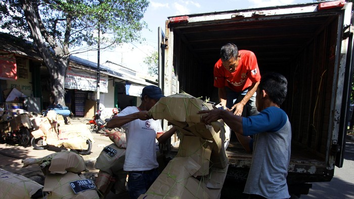 Pekerja ekspedisi menaikkkan sepeda motor kedalam truk box yang akan dipaketkan di Kawasan Pasar Senen, Jakarta Pusat, Senin (14/7/2014). menjelang lebaran jasa pengiriman sepeda motor semakin meningkat.