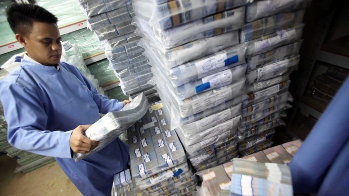 Seorang petugas mengangkut uang rupiah di sentra kas Bank BRI, di Jakarta, Rabu (28/8/2013). Melemahnya nilai tukar rupiah terhadap dollar Amerika Serikat membuat beban utang luar negeri bertambah. File/detikFoto.