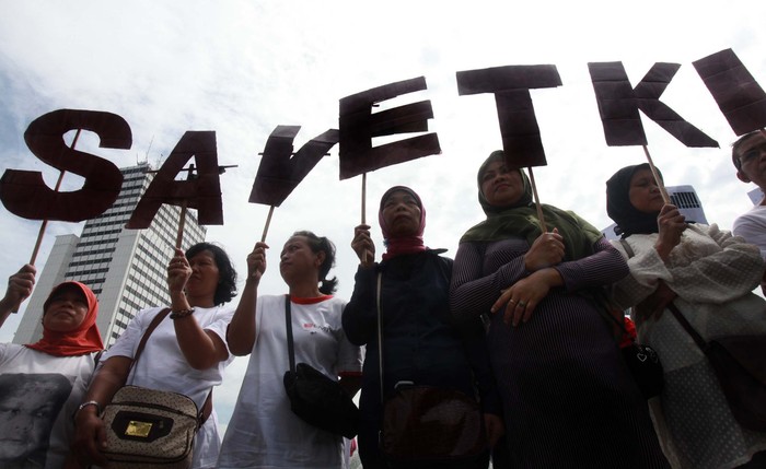 Puluhan aktivis yang tergabung dalam Migran Care melakukan aksi teatrikal Save TKI di Bundaran HI, Jakarta, Selasa (18/12).