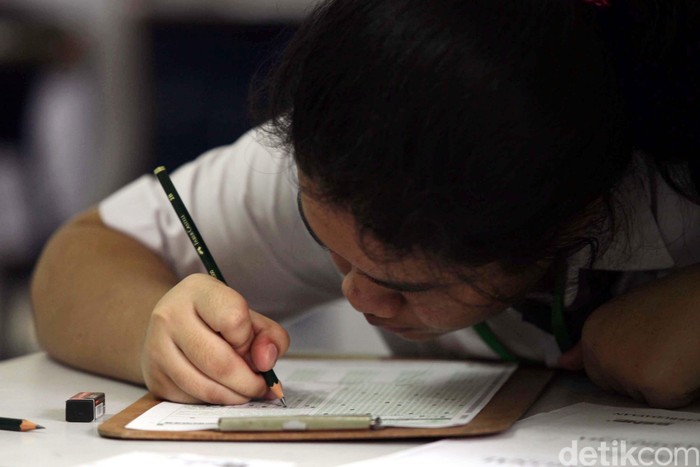 Siswa-siswi mengikuti ujian nasional di SMP Negeri 1 Jakarta, Jakarta Pusat, Senin (22/4). Sebanyak 3.717.498 siswa SMP/MTs seluruh Indonesia serentak menjalankan Ujian Nasional (UN) mulai hari ini. File/detikFoto.