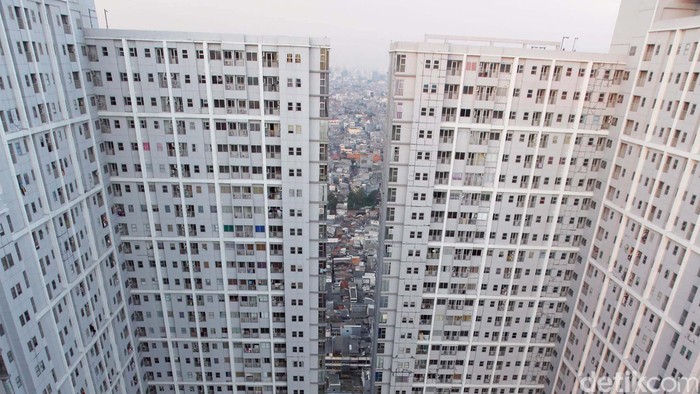 Apartemen dengan fasilitas kolam renang dan taman bermain berlatar belakang pemukiman padat penduduk di Season City, Jakarta Barat, Senin (8/7). Mahal dan terbatasnya lahan pemukiman serta tingkat kebutuhan primer terhadap hunian terutama yang terletak di pusat kota atau dekat kawasan bisnis yang kian terbatas, membuat pemukiman vertikal jadi incaran terutama oleh kaum Urban. File/detikFoto.