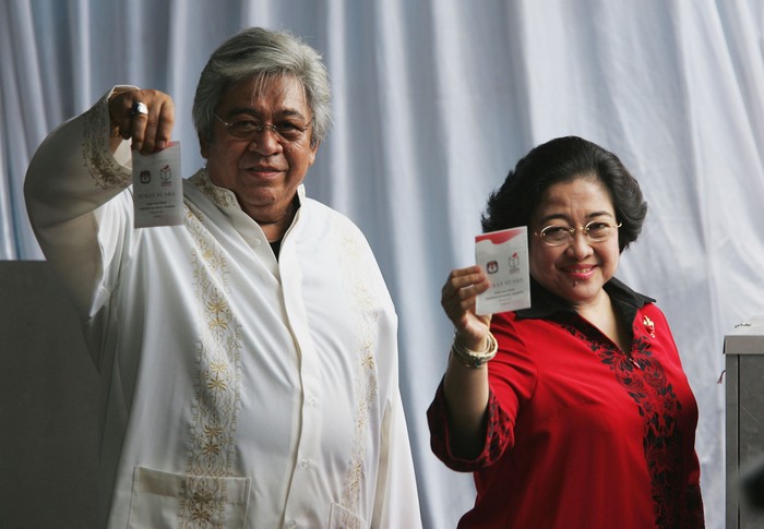 JAKARTA, INDONESIA - SEPTEMBER 20: Indonesian President Megawati Sukarnoputri, accompanied by her husband Taufik Kiemas, show their ballot cards after casting their votes on September 20, 2004 in Jakarta, Indonesia. Retired army general Susilo Bambang Yudhoyono is expected to defeat incumbent Sukarnoputri following a peaceful and orderly vote. (Photo by: Dimas Ardian/Getty Images)