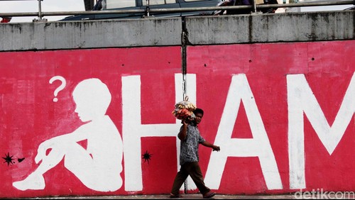 Pedagang melewati mural soal 14 tahun reformasi dan Hak Asasi Manusia (HAM) di Jl S.Parman, Grogol, Jakarta Barat, Kamis (24/5/2012). Mural
yang dibuat didepan kampus Trisakti tersebut menyindir kebijakan pemerintah yang seakan melupakan para martir reformasi 14 tahun lalu. File/DetikFoto.