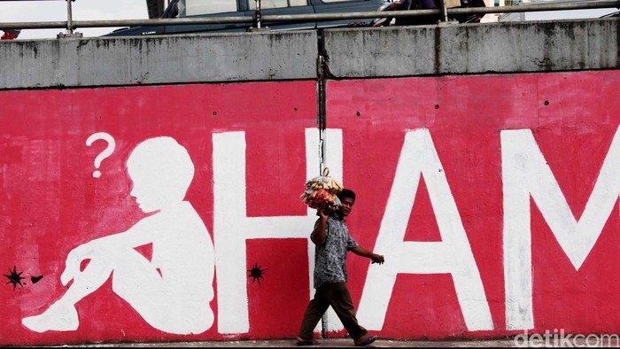 Pedagang melewati mural soal 14 tahun reformasi dan Hak Asasi Manusia (HAM) di Jl S.Parman, Grogol, Jakarta Barat, Kamis (24/5/2012). Mural
yang dibuat didepan kampus Trisakti tersebut menyindir kebijakan pemerintah yang seakan melupakan para martir reformasi 14 tahun lalu. File/DetikFoto.