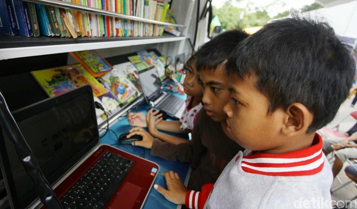 Executive Vice President Human Capital Astra Credit Companies Matilda Esther berdialog dengan anak-anak yang sedang menggunakan sarana Laboratorium Bergerak di Taman Ismail Marzuki, Jakarta, Minggu (23/11/2014). ACC memberikan fasilitas belajar berupa mobil yang berisi buku, komputer dan internet untuk Sanggar Anak Akar fasilitas tersebut juga akan didistribusikan keliling untuk masyarakat khususnya anak-anak yang ingin belajar.