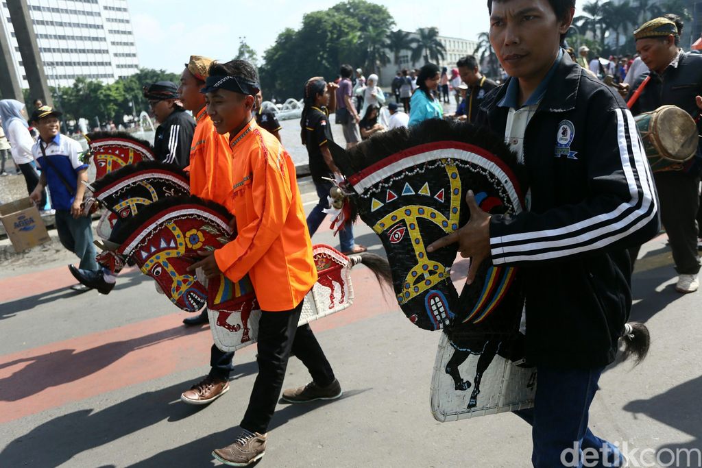 Sejumlah seniman kuda lumping beraksi saat car free day di Bundaran Hotel Indonesia, Jakarta, Minggu (21/12/2014). Kegiatan ini dilakukan dalam rangka menggalang dana sumbangan dari pengunjung Car Free Day untuk korban longsor Banjarnegara.