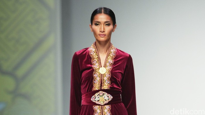 kesan oriental dan gabungannya tradisi Indonesia kental terasa dalam dominasi warna merah. Busana dibentuk dalam siluet kebaya dan kain dalam warna merah marun, yang diberi sentuhan oriental lewat aplikasi bordir emas berbentuk burung phoenix.