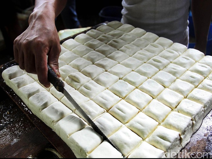 Perajin tahu tempe termasuk paling yang terpukul bila nilai tukar rupiah terhadap dolar AS terus melemah hingga tembus Rp 13.000,-. Bahan baku tempe dan tahu, yaitu kedelai untuk industri tempe dan tahu saat ini mayoritas masih diimpor dari AS dan Brasil. Kurs dolar yang menguat membuat biaya produksi lebih tinggi karena ada kenaikan harga kedelai akibat kenaikan kurs. Perajin memproduksi tahu di pabrik tahu kawasan Duren Tiga, Jakarta Selatan, Jumat (13/03/2015).