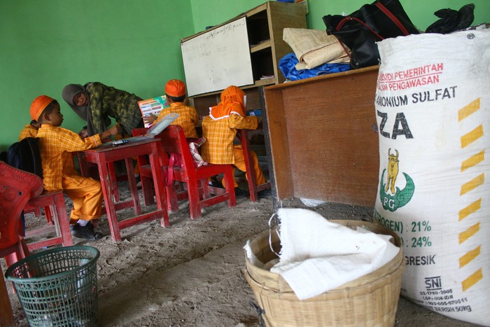 Guru Raudhatul Athfal (RA) Perwanida, Yuntari (33) mengajar lima siswanya di sekolah  taman kanak-kanak yang menggunakan rumah warga sebagai kelas di dusun Poncol, Ngawi, Jawa Timur, Kamis (26/3). Kelas tersebut menampung anak-anak yang berada di pelosok desa karena tidak ada sekolah lain dalam radius 2 kilometer. ANTARA FOTO/Ari Bowo Sucipto/Rei/mes/15.