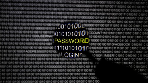 A magnifying glass is held in front of a computer screen in this file picture illustration taken in Berlin May 21, 2013. Hackers broke into U.S. government computers, possibly compromising the personal data of 4 million current and former federal employees, and investigators were probing whether the culprits were based in China, U.S. officials said on June 4, 2015. REUTERS/Pawel Kopczynski/Files
