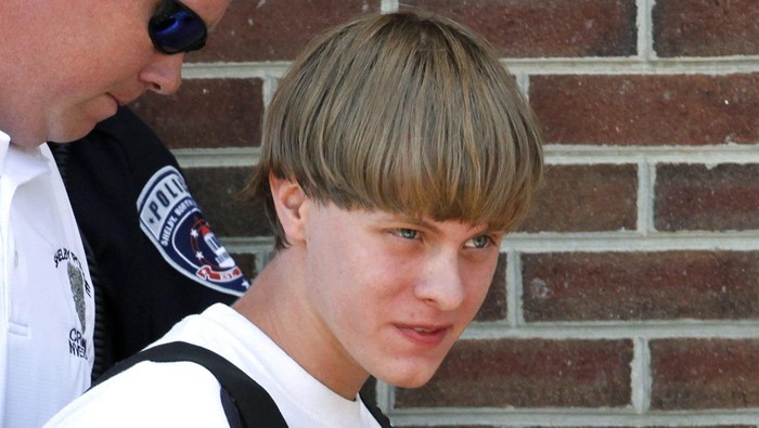 Police lead suspected shooter Dylann Roof into the courthouse in Shelby, North Carolina, June 18, 2015.   Roof, a 21-year-old with a criminal record, is accused of killing nine people at a Bible-study meeting in a historic African-American church in Charleston, South Carolina, in an attack U.S. officials are investigating as a hate crime.  REUTERS/Jason Miczek