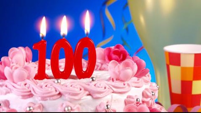 Kue ulang tahun dengan lilin berbentuk angka 100