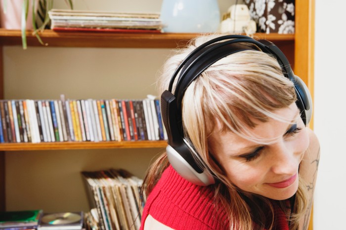 wanita sedang mendengarkan musik