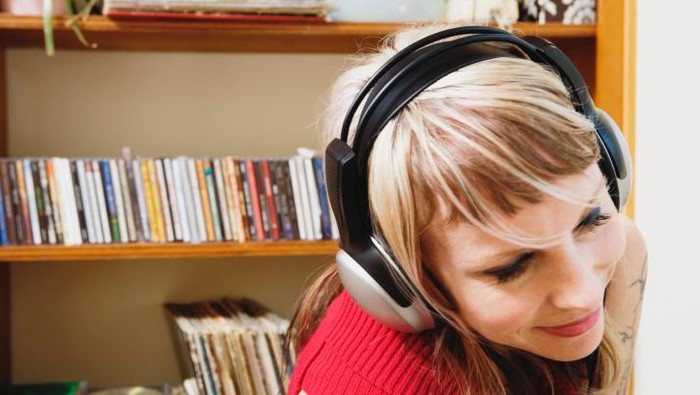 wanita sedang mendengarkan musik