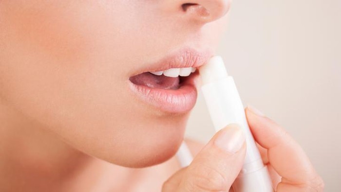 wanita memakai lipbalm