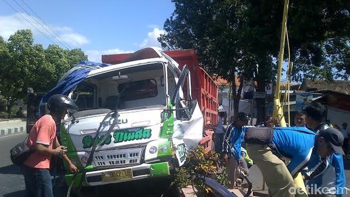 Dump Truk Muat Batu Nangkring di Median Jalan