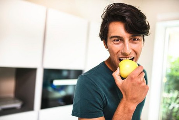eat apple pria muda memakan sebutir apel hijau