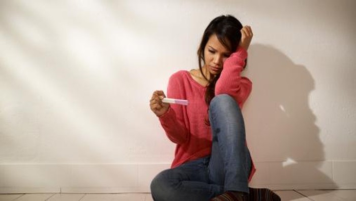 young woman with pregnancy test kit