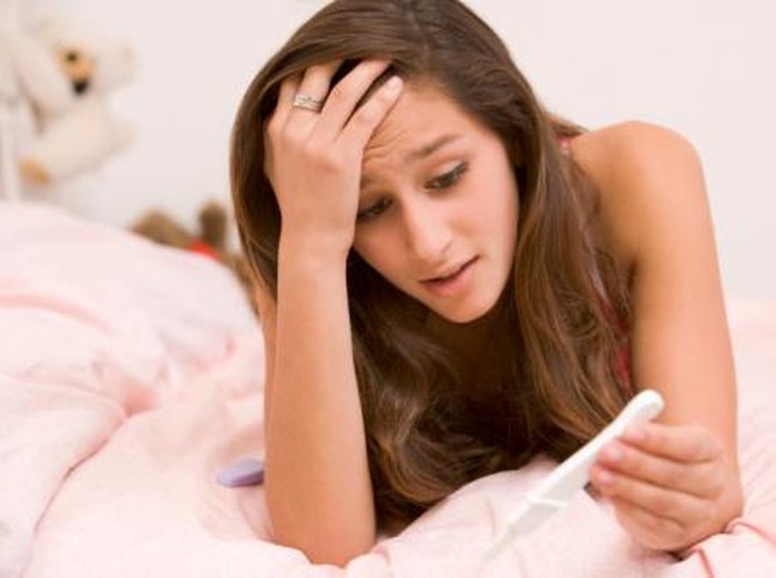 Ilustrasi tes kehamilan young woman with pregnancy test kit