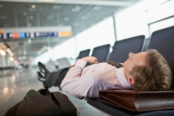 Businessman sleeping in airport terminal