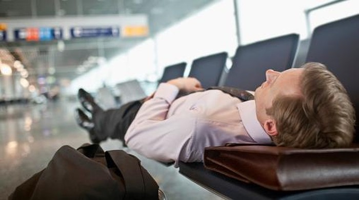 Businessman sleeping in airport terminal