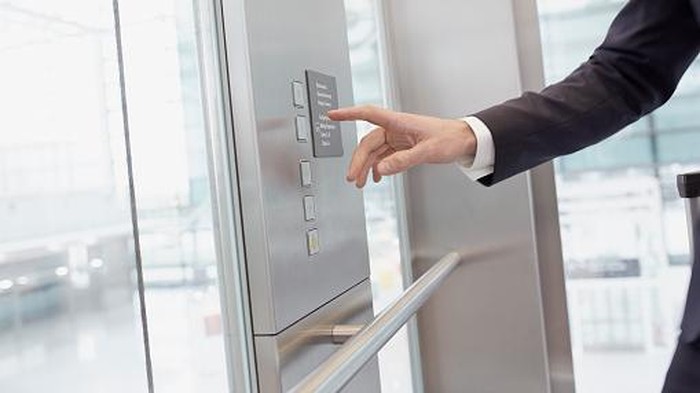 ilustrasi lift Hand of businessman pressing control in elevator