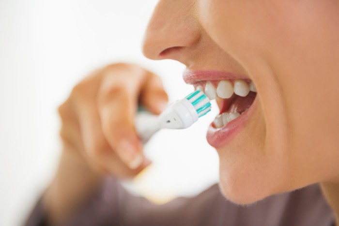 ilustrasi menyikat gigi closeup on happy young woman brushing teeth