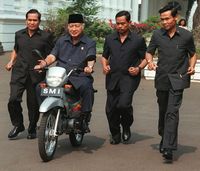 Soeharto menaiki sepeda motor di Istana Negara.